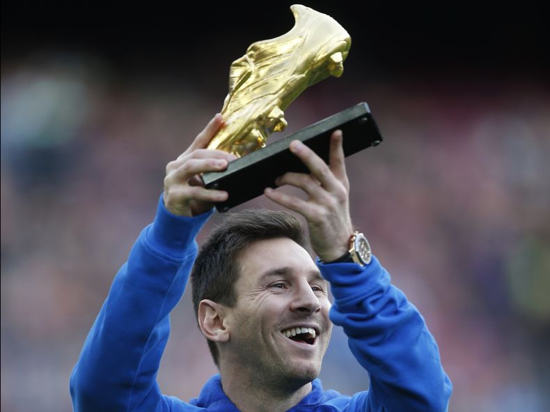 Lionel Messi alza el Bot&iacute;n de Oro que recibi&oacute; por anotar 46 goles la temporada pasada antes de un partido de la liga espa&ntilde;ola entre Barcelona y Granada en el Camp Nou. Barcelona inform&oacute; el jueves 28 de noviembre de 2013 que Mes
