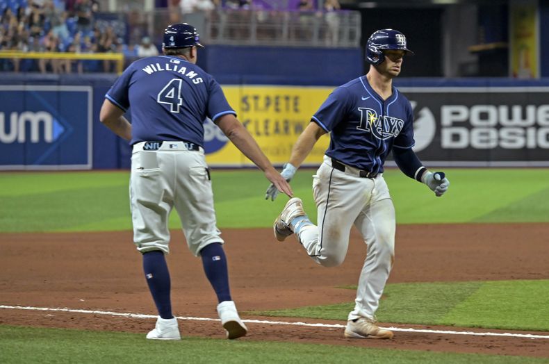 Brady Williams, coach de la antesala de los Rays de Tampa Bay, felicita a Ben Rortvedt, quien conectó un jonrón de dos carreras ante los Marineros de Seattle, el martes 25 de junio de 2024 (AP Foto/Steve Nesius)