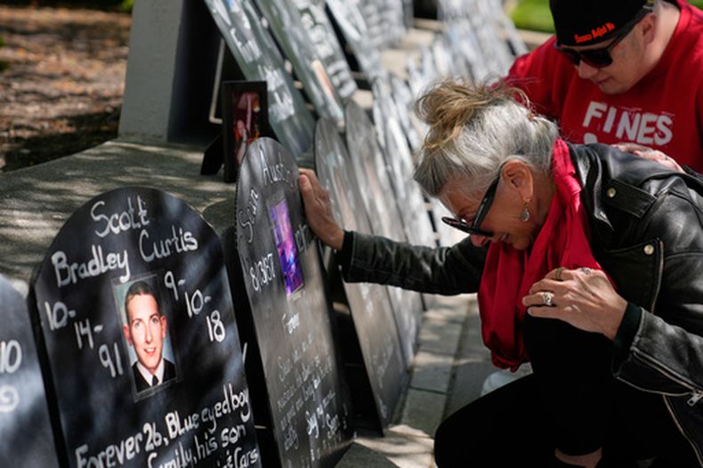 Tanny Austin llora al mirar las lápidas con los nombres de víctimas de la crisis de opioides, entre las que está su hijo Sean Austin, en una marcha fuera de un tribunal de Newark, Nueva Jersey, el martes 21 de abril de 2026. (AP Foto/Seth Wenig)