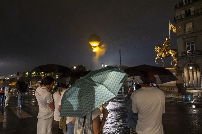 El público ingresa a la zona vallada tras la ceremonia de apertura de los Juegos Olímpicos de París, el sábado 27 de julio de 2024. (AP Foto/David Goldman)