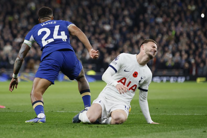 James Maddison, derecha, de Tottenham, resulta lesionado durante el partido de futbol de la Liga Premier de Inglaterra entre Tottenham Hotspur y Chelsea, en el estadio Tottenham Hotspur, en Londres, el lunes 6 de noviembre de 2023. (AP Foto/David Cliff)