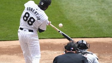 El cubano de los Medias Blancas de Chicago Luis Robert Jr. impacta un cuadrangular de dos carreras ante el abridor de los Tigres de Detroit Kenta Maeda, durante la primera entrada del juego de béisbol, el sábado 30 de marzo de 2024, en Chicago. (AP Foto/Charles Rex Arbogast)