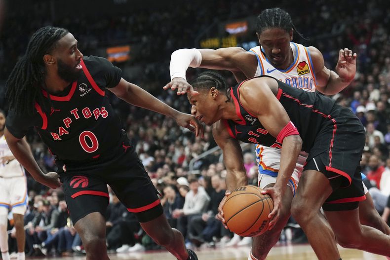El escolta de los Raptors de Toronto, Jahmius Ramsey, al frente a la derecha, trabaja contra el alero del Thunder de Oklahoma City, Jalen Williams, mientras el escolta de los Raptors, Javon Freeman-Liberty, a la izquierda, durante la segunda mitad del partido de baloncesto de la NBA, el viernes 22 de marzo de 2024, en Toronto. (Nathan Denette/The Canadian Press vía AP)