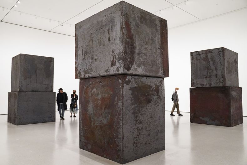 ARCHIVO - Personas miran Equal de Richard Serra en el Museo de Arte Moderno en los nuevos espacios de exhibición el 13 de noviembre de 2020, en Nueva York. Serra, conocido por convertir paredes curvas de acero oxidado y otros materiales maleables en obras de arte a gran escala que ahora están repartidas por todo el mundo, murió el martes 26 de marzo de 2024 en su casa en Long Island, Nueva York. Tenía 85 años. (Foto AP/John Minchillo, archivo)