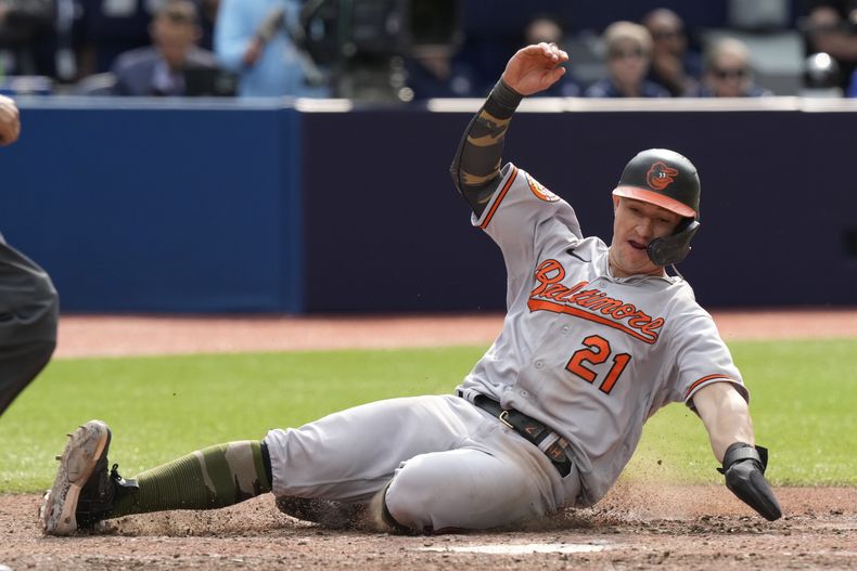 El jardinero izquierdo de los Orioles de Baltimore, Austin Hays, se desliza a home para anotar la sexta carrera de su equipo en el juego de las Grandes Ligas contra los Azulejos de Toronto, el domingo 21 de mayo de 2023, en Toronto. (Frank Gunn/The Canadian Press via AP)