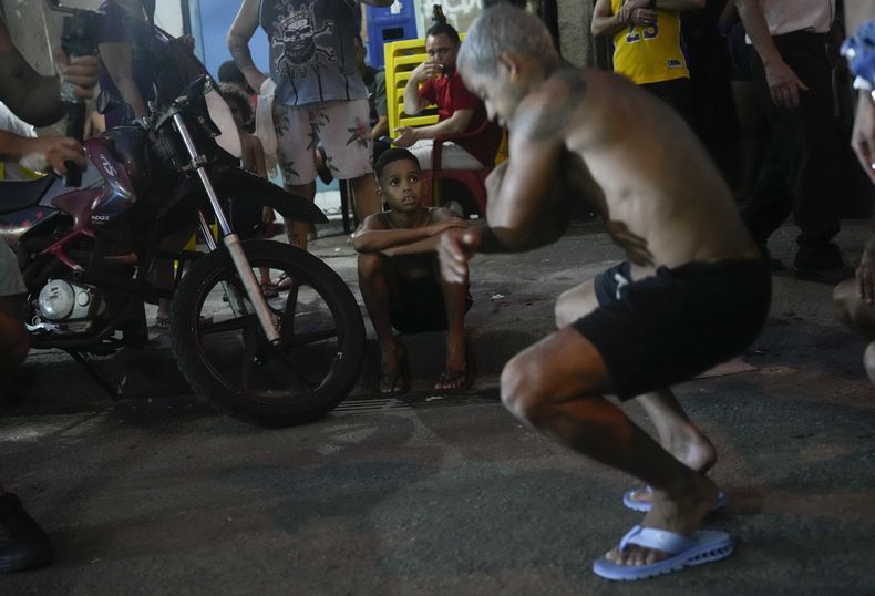 ARCHIVO - Un niño ve a jóvenes bailando passinho en la favela de Rocinha de Río de Janeiro, Brasil, el 11 de abril de 2024. El passinho ha ayudado a terminar con el estigma de violencia y narcotráfico de las favelas. Fue declarado patrimonio cultural inmaterial por los legisladores estatales. (Foto AP/Silvia Izquierdo, archivo)