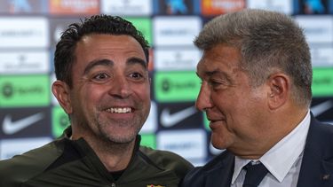 El técnico del Barcelona Xavi Hernández sonríe al lado del presidente Joan Laporta durante una rueda de prensa, el jueves 25 de abril de 2024. (AP Foto/Emilio Morenatti)