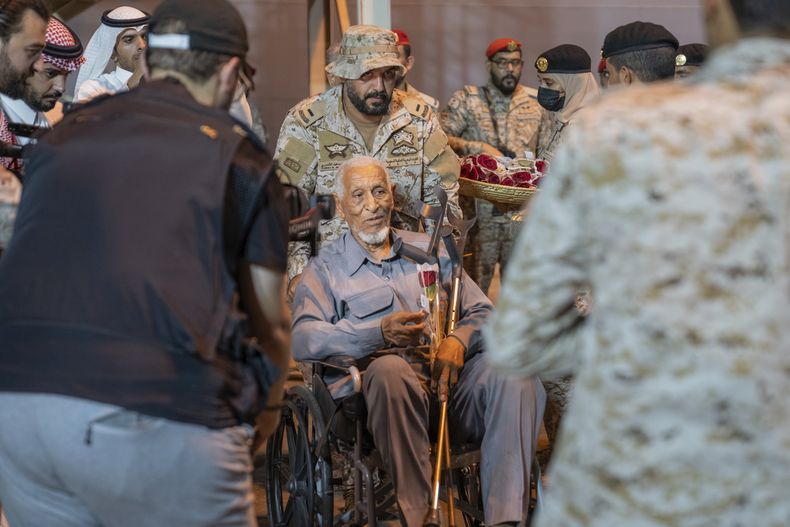 En esta fotografía proporcionada por el Ministerio de Medios de Arabia Saudí, un evacuado en silla de ruedas recibe ayuda de soldados saudíes en Yeda, Arabia Saudí, el lunes 24 de abril de 2023, tras haber sido evacuado de Sudán para huir de los combates. (Ministerio de Medios de Arabia Saudí vía AP)