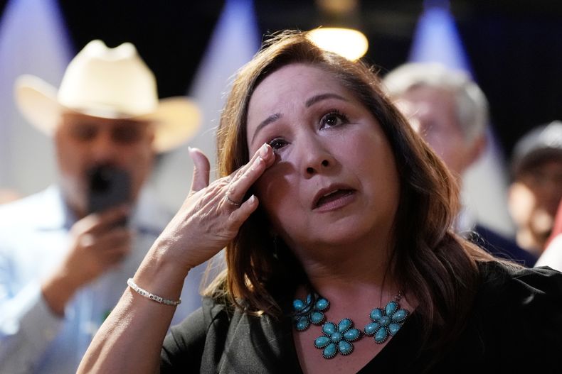 Adelita Grijalva, candidata demócrata por Arizona, se enjuga una lágrima mientras sus hijos hablan sobre ella en el escenario tras ser declarada ganadora frente al republicano Daniel Butierez para ocupar el escaño del Distrito Legislativo 7 --que solía ocupar el difunto representante federal Raúl Grijalva-- en una elección especial el martes 23 de septiembre de 2025, en Tucson, Arizona. (AP Foto/Ross D. Franklin)