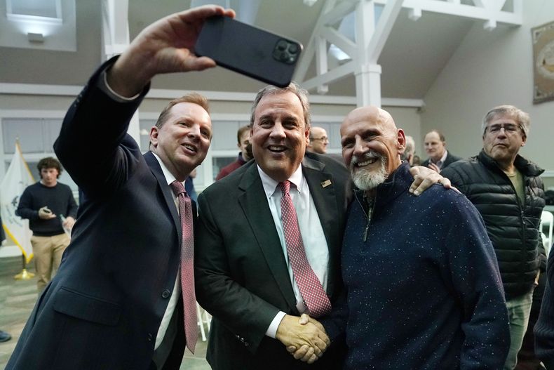 El exgobernador de Nueva Jersey, Chris Christie, al centro, posa para una foto después de una plática en el New England College, el 20 de abril de 2023, en Henniker, Nuevo Hampshire. (AP Foto/Charles Krupa)
