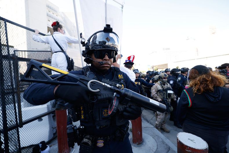 Manifestantes se enfrentan a agentes de la ley fuera del Metropolitan Detention Center el sábado 6 de junio de 2026, en la conmemoración de las incursiones federales de inmigración y las protestas comunitarias de hace un año en Los Ángeles. (AP Foto/Jill Connelly)
