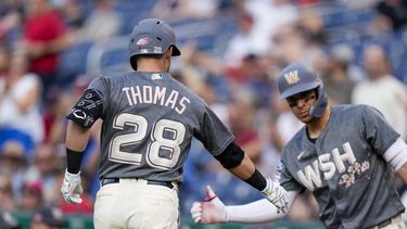 Lane Thomas, de los Nacionales de Washington, festeja con el dominicano Jeimer Candelario, luego de batear un jonrón ante los Gigantes de San Francisco, el viernes 21 de julio de 2023 (AP Foto/Alex Brandon)