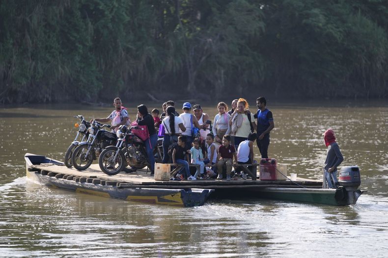 Los residentes cruzan un río hacia Venezuela desde Tibú, Colombia, el martes 21 de enero de 2025, luego de ataques guerrilleros que mataron a decenas y obligaron a miles a huir de sus hogares en la región del Catatumbo. (AP Foto/Fernando Vergara)