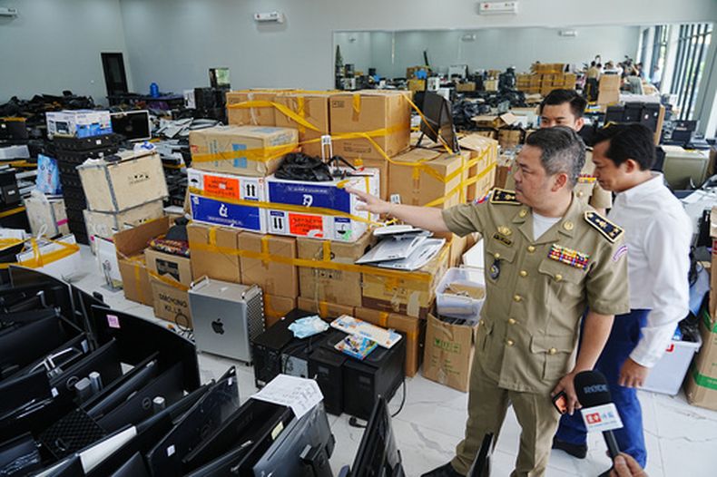 El jefe policial camboyano Bun Sosekha muestra a los periodistas objetos confiscados en un centro de estafas en Nom Pen, Camboya, el 11 de marzo del 2026. (AP foto/Heng Sinith)
