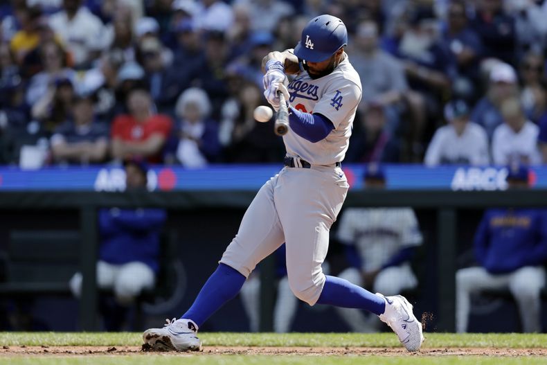 Jason Heyward de los Dodgers de Los Ángeles pega un sencillo remolcador en la cuarta entrada del encuentro ante los Marineros de Seattle el domingo 17 de septiembre del 2023. (AP Foto/John Froschauer)