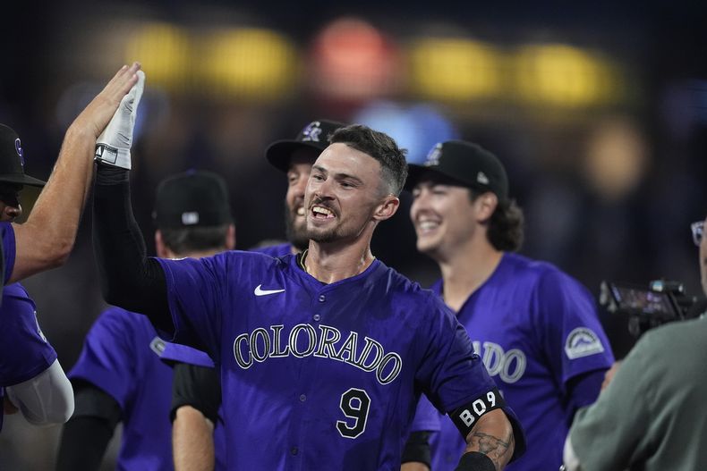 Brenton Doyle, de los Rockies de Colorado, festeja con sus compañeros tras conectar el elevado que significó el triunfo ante los Dodgers de Los Ángeles, el miércoles 19 de junio de 2024 (AP Foto/David Zalubowski)