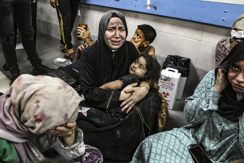 Palestinos heridos por un ataque contra el hospital Al Ahli sentados en el piso del hospital Al Shifa, en Gaza, Franja de Gaza, el martes 17 de octubre de 2023. El Ministerio de Salud palestino controlado por Hamas dijo que un ataque aéreo israelí causó la explosión que mató a cientos en el hospital Al Ahli, pero las fuerzas militares israelíes dijeron que había sido por un cohete malogrado lanzado por otros combatientes palestinos. (AP Foto/Abed Khaled)