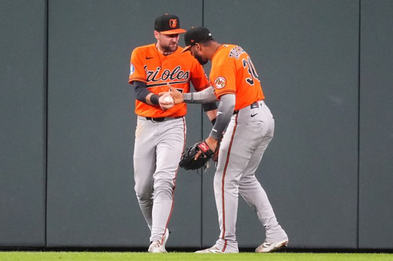 Leody Taveras, derecha, jardinero derecho de los Orioles de Baltimore, felicita a Colton Cowser, jardinero central, después de que le robara a Jake McCarthy, de los Rockies de Colorado, un jonrón de dos carreras para cerrar la novena entrada del juego de béisbol de Grandes Ligas, el lunes 31 de agosto de 2026, en Denver. (AP Foto/David Zalubowski)