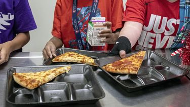 ARCHIVO - Estudiantes de segundo grado seleccionan sus comidas durante el almuerzo en la cafetería, el 12 de diciembre de 2022, en una escuela primaria en Scottsdale, Arizona. Más estudiantes en las escuelas que sirven a las comunidades de bajos ingresos serán elegibles para recibir el desayuno y el almuerzo sin costo alguno en virtud de un cambio de regla anunció el martes, 26 de septiembre de 2023, por el Departamento de Agricultura de Estados Unidos. (AP Foto/Alberto Mariani, Archivo)