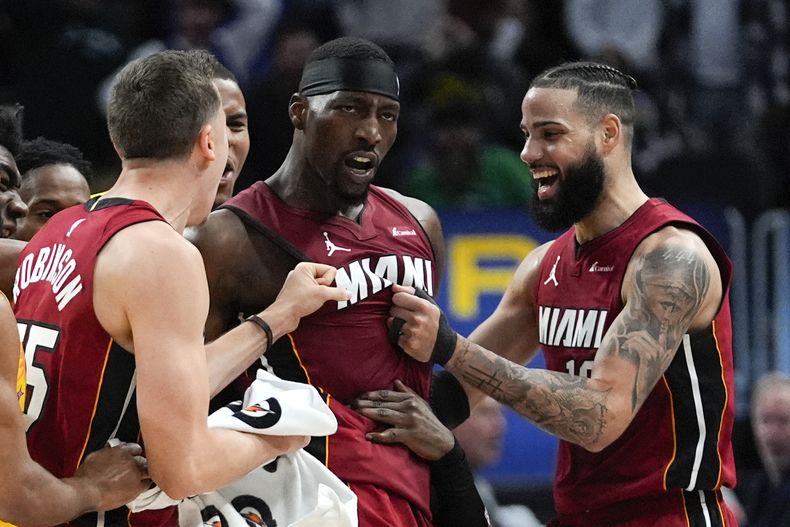 El centro del Heat de Miami, Bam Adebayo celebra su lanzamiento ganador junto a Duncan Robinson (izquierda), y Caleb Martin (derecha) en la segunda mitad del juego de baloncesto de la NBA ante los Pistons de Detroit, en Detroit, el domingo 17 de marzo de 2024. (AP Foto/Paul Sancya)