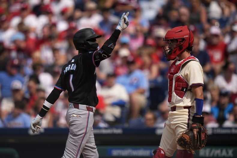 Nick Gordon, de los Marlins de Miami, festeja frente a Garrett Stubbs, de los Filis de Filadelfia, luego de conseguir un jonrón en el encuentro del sábado 29 de junio de 2024 (AP foto/Matt Slocum)