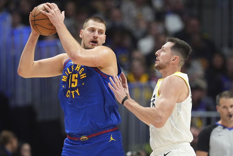 Nikola Jokic, de los Nuggets de Denver, busca enviar un pase frente a Drew Eubanks, del Jazz de Utah, el sábado 2 de noviembre de 2024 (AP Foto/David Zalubowski)