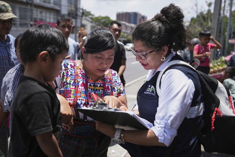 Un familiar de un menor no acompañado deportado desde Estados Unidos revisa la lista de deportados afuera del Aeropuerto Internacional La Aurora en Ciudad de Guatemala el 31 de agosto del 2025. (AP foto/Moises Castillo)