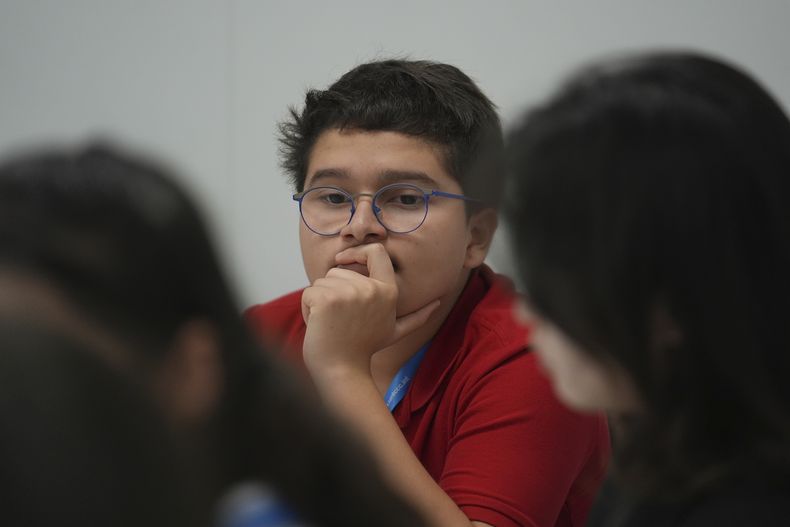 El activista climático colombiano Francisco Vera Manzanares, de 15 años, en el centro, escucha durante un foro con activistas jóvenes, el martes 12 de noviembre de 2024 en la cumbre climática en Bakú, Azerbaiyán. Vera ha sido amenazado desde que tenía 11 años y, ahora, cuatro años después, no han cesado, pese a que se exilió en España, advirtieron el miércoles 27 de noviembre de 2024 relatores especiales de las Naciones Unidas. (AP Foto/Joshua A. Bickel)