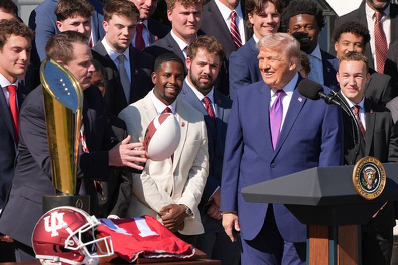 El presidente Donald Trump recibe un balón de fútbol americano de manos del entrenador Curt Cignetti durante un evento de bienvenida a la Universidad de Indiana, campeona nacional del Playoff del Fútbol Americano Universitario en 2026, en el jardín sur de la Casa Blanca, el lunes 11 de mayo de 2026, en Washington. (AP Foto/Jacquelyn Martin)