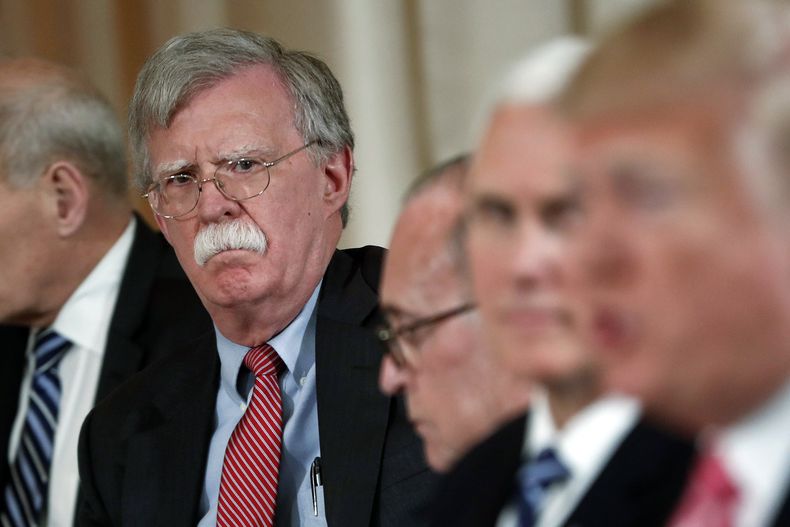 ARCHIVO - El asesor de seguridad nacional John Bolton, a la izquierda, escucha al presidente Donald Trump, a la derecha, hablar durante un almuerzo de trabajo con el primer ministro japonés, Shinzo Abe, en el club privado Mar-a-Lago de Trump, el 18 de abril de 2018 en Palm Beach, Florida (AP Foto/Pablo Martínez Monsiváis)