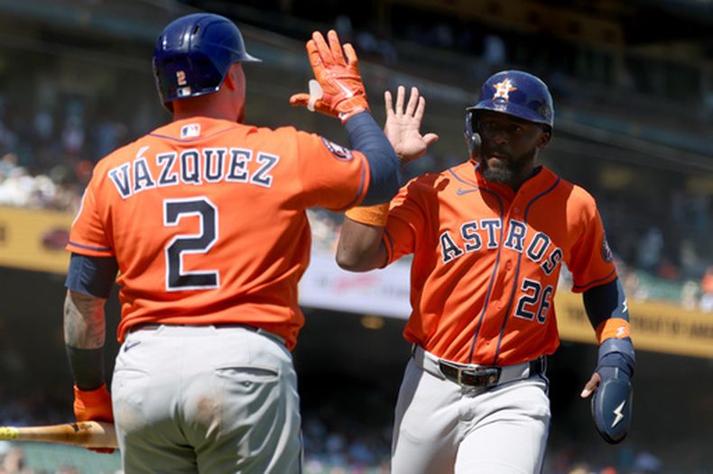 El puertorriqueño Christian Vázquez felicita a Taylor Trammell, su compañero de los Astros de Houston, tras anotar ante los Gigantes de San Francisco, el miércoles 12 de agosto de 2026 (AP Foto/Jed Jacobsohn)