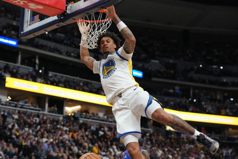 Yaxel Lendeborg, de los Warriors de Golden State, se cuelga del aro después de clavar el balón en la segunda mitad del juego de baloncesto de la NBA en contra de los Nuggets de Denver, el lunes 26 de octubre de 2026, en Denver. (AP Foto/David Zalubowski)
