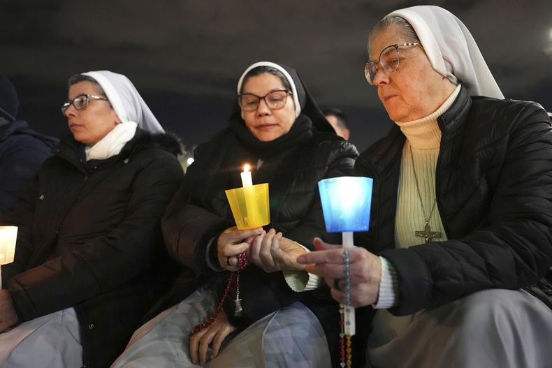 Tres monjas asisten al rezo del rosario por la salud del papa Francisco, guiado por el cardenal Víctor Manuel Fernández, en la Plaza de San Pedro del Vaticano, el 28 de febrero de 2025. (AP Foto/Kirsty Wigglesworth)