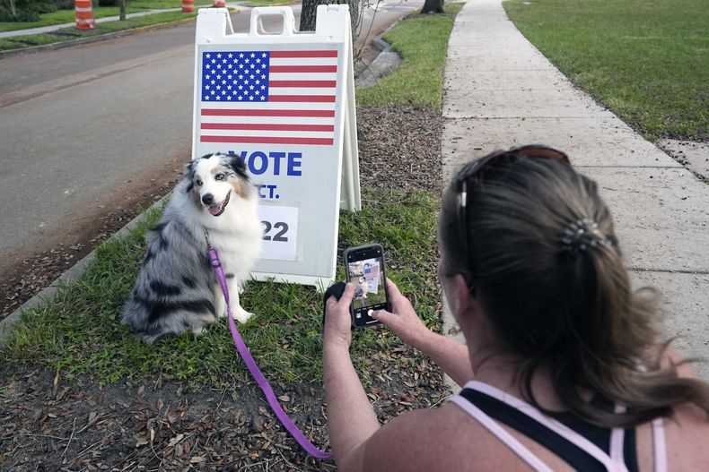 Susan Finan le toma una foto a su perra, Daisey, mientras espera a que su hija vote en la escuela secundaria Glenridge, el martes 5 de noviembre de 2024, en Orlando, Florida. (AP Foto/John Raoux)