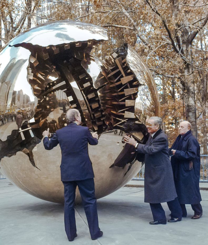 ARCHIVO - Boutros Boutros-Ghali (centro), secretario general de las Naciones Unidas, empuja la obra Esfera dentro de una esfera del escultor italiano Arnaldo Pomodoro (derecha) durante su inauguración en la ONU el jueves 21 de noviembre de 1996. El ministro de Asuntos Exteriores italiano, Umberto Dini (izquierda), le ayuda a girar la escultura de bronce de ocho toneladas. (Foto AP/Mark Lennihan)