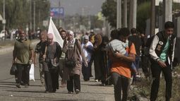 Una mujer carga con una bandera blanca para evitar recibir disparos mientras palestinos huyen de la Ciudad de Gaza hacia el sur de la Franja, en la calle Salah al-Din, en Bureij, el 7 de noviembre de 2023. (AP Foto/Mohammed Dahman)
