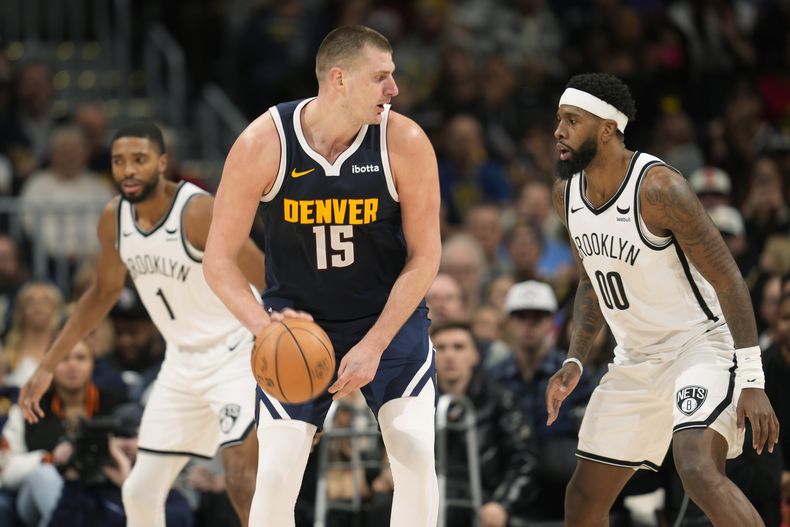 El serbio Nikola Jokic, de los Nuggets de Denver, conduce el balón frente a Royce ONeale, de los Nets de Brooklyn, en el partido del jueves 14 de diciembre de 2023 (AP Foto/David Zalubowski)