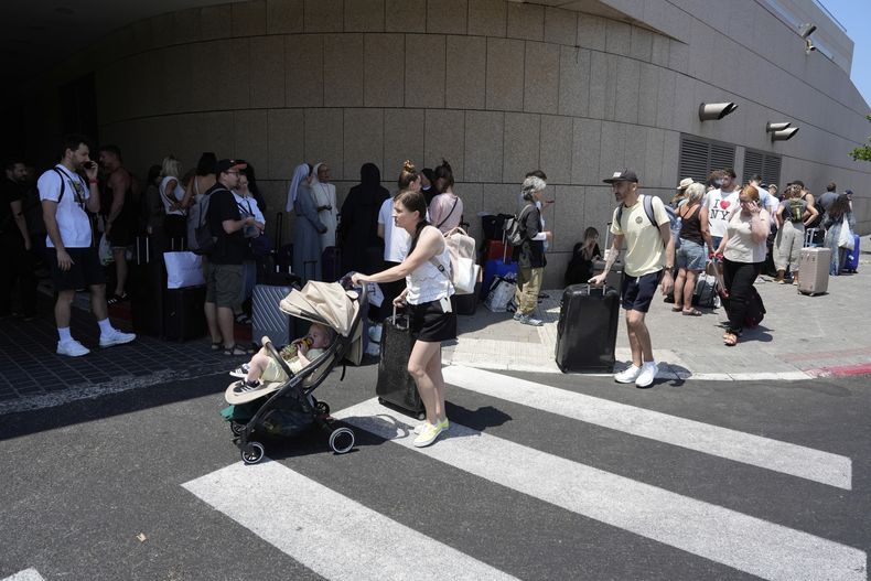 Ciudadanos de Polonia y Austria se reúnen en un hotel en Tel Aviv, Israel, para ser evacuados tras los fuertes ataques iraníes contra Israel, el martes 17 de junio de 2025. (AP Foto/Baz Ratner)