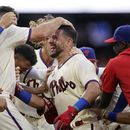 Kyle Schwarber de los Filis de Filadelfia celebra con sus compañeros tras batear el elevado de sacrificio ante el relevista de los Padres de San Diego Tim Hill en la 12ma entrada del juego del domingo 16 de julio del 2023. (AP Foto/Matt Slocum)