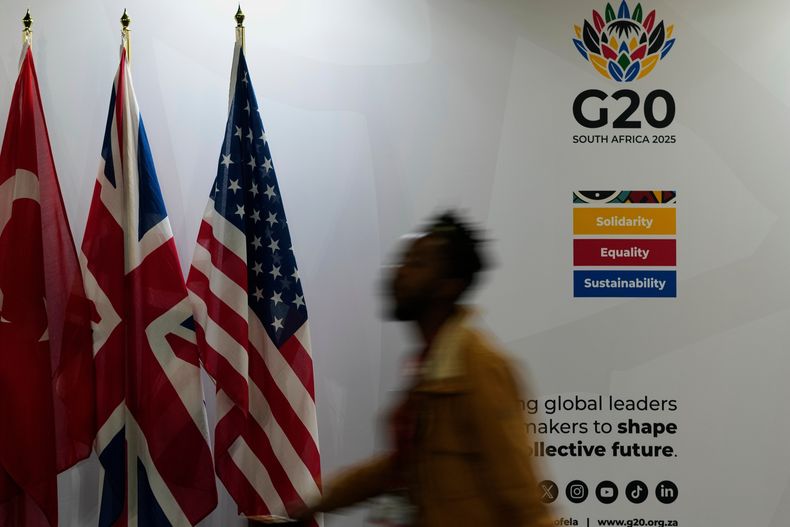 Un periodista pasa enfrente de unas banderas en la sede de la cumbre del G20 en Johannesburgo, Sudáfrica, el 21 de noviembre del 2025. (AP foto/Themba Hadebe)