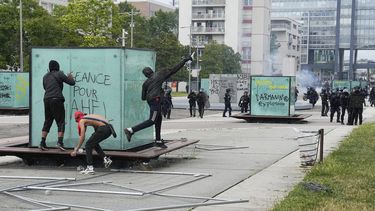 Jóvenes lanzan una botella a la policía durante disturbios el jueves 29 de junio de 2023 en Nanterre, a las afueras de París. En total, más de 3.600 personas han sido detenidas en los disturbios en Francia desde la muerte de Nahel el 27 de junio, con una edad media de 17, según el Ministerio del Interior. (AP Foto/Michel Euler)