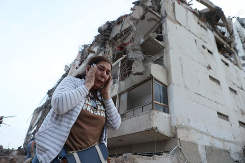 Una mujer pasa junto a un edificio dañado durante un terremoto en La Guaira, Venezuela, el jueves 25 de junio de 2026. (AP Foto/Pedro Mattey)