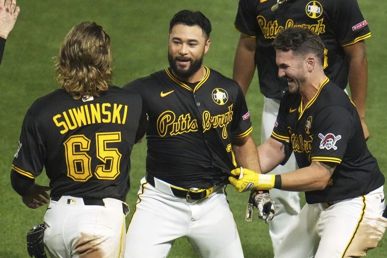 Isiah Kiner-Falefa celebra con sus compañeros de los Piratas de Pittsburgh Jack Suwinski y Spencer Horwitz su carrera de la victoria ante los Gigantes de San Francisco el lunes 4 de agosto del 2025. (AP Foto/Gene J. Puskar)