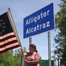 Rana Mourer ondea una bandera estadounidense fuera del centro de detención de inmigrantes conocido como “Alcatraz de los Caimanes” en la instalación de Entrenamiento y Transición de Dade-Collier, el sábado 12 de julio de 2025 en Ochopee, Florida. (AP Foto/Alexandra Rodriguez)