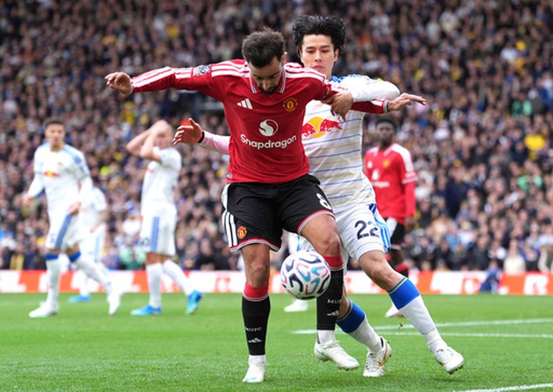 Bruno Fernandes del Manchester United pelea por el balón con Ap Tanaka del Leeds en el encuentro de la Liga Premier el domingo 18 de octubre del 2026. (Annabel Lee-Ellis/PA via AP)