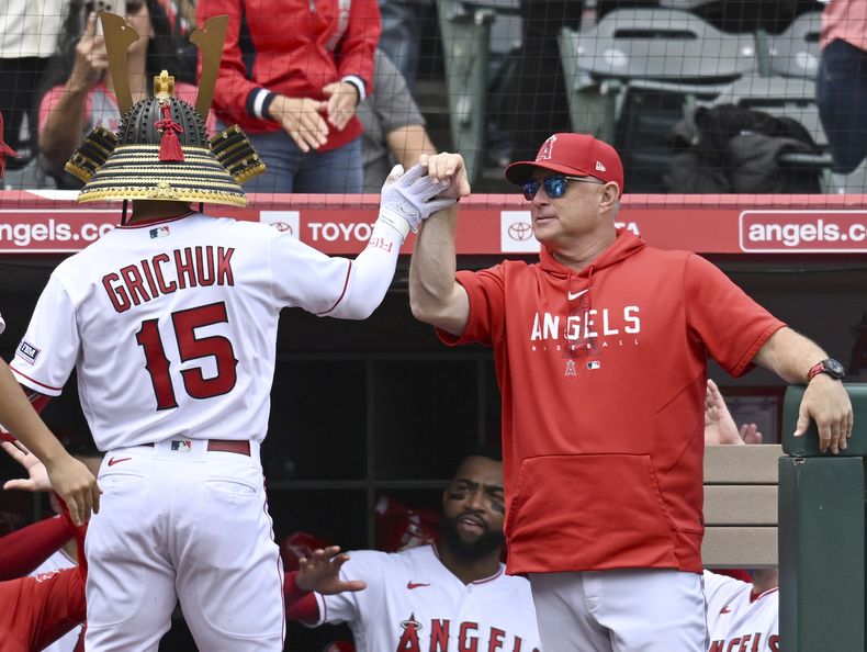 El jardinero derecho de los Angelinos de Los Ángeles Randal Grichuk felicitado por el mánager Phil Nevin en la tercera entrada del juego ante los Atléticos de Oakland del domingo primero de octubre del 2023. (AP Foto/John McCoy)
