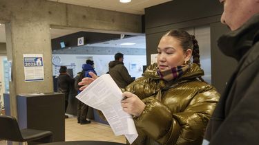 Una mujer lee su boleta antes de depositar el voto anticipado en las elecciones parlamentarias en Groenlandia, en la municipalía de Nuuk, Groenlandia, el 10 de marzo de 2025. (AP Foto/Evgeniy Maloletka)