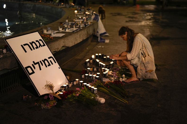 Una mujer enciende una vela en honor a las víctimas del ataque de Hamas durante una vigilia en Dizengoff en el centro de Tel Aviv el viernes 13 de octubre del 2023. (AP Foto/Francisco Seco)