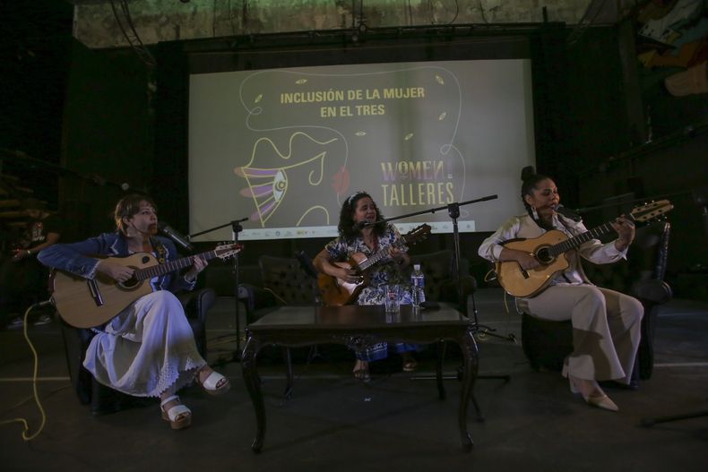 Jany Quiñones, izquierda, Enid Rosales, centro, y Yarima Blanco actúan durante una charla sobre la inclusión de la mujer en el tres, un instrumento tradicional cubano, en la Fábrica de Arte, en La Habana, el viernes 7 de marzo de 2025. (Foto AP/Ariel Ley)