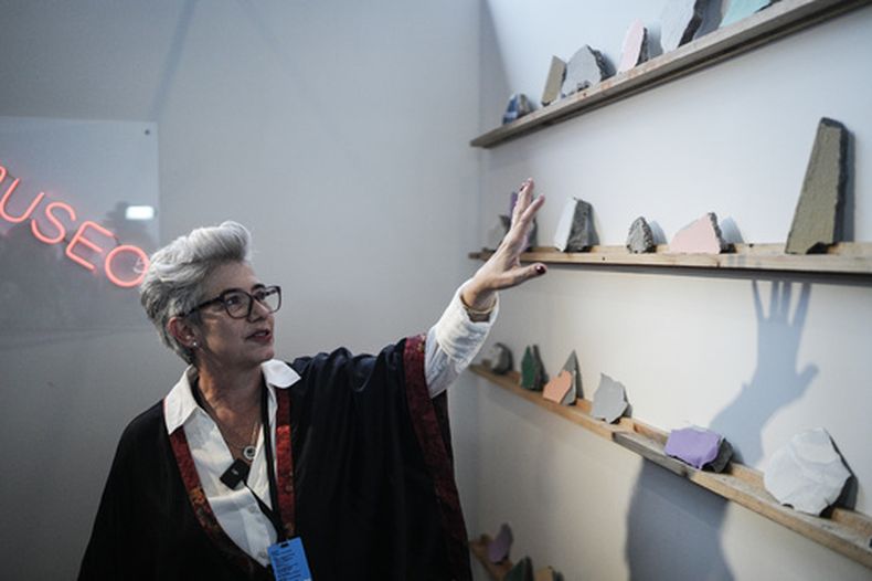 La artista colombiana Rosa Ángel muestra escombros de un terremoto en una feria de arte internacional organizada para recaudar fondos destinados a reconstruir las viviendas de las personas desplazadas por el sismo, en Bogotá, Colombia, el jueves 24 de septiembre de 2026. (Foto AP/Ivan Valencia)